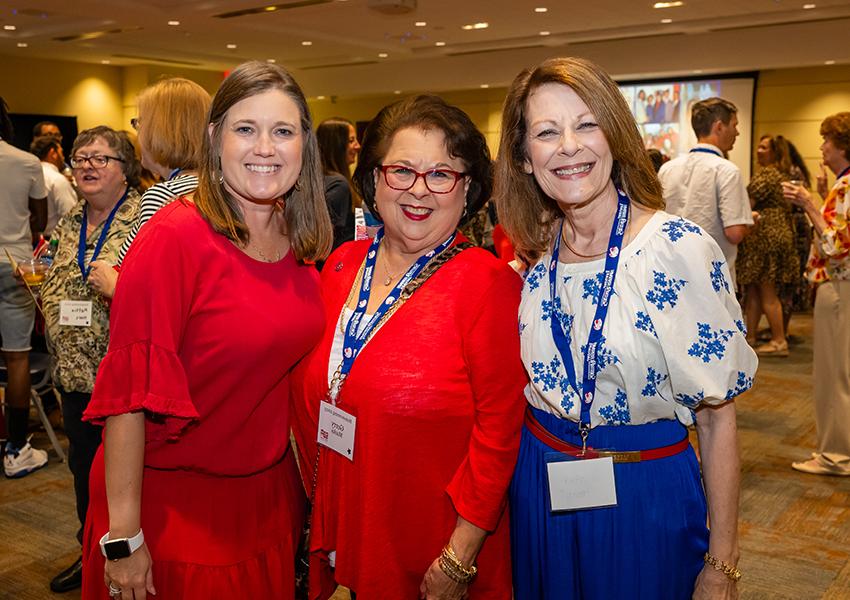 Three alumni smiling.