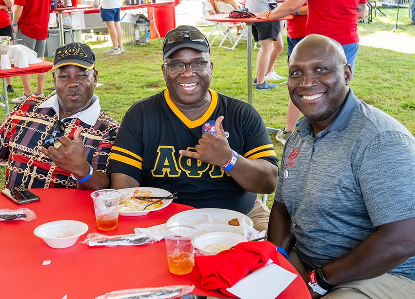 Three alumni smiling.