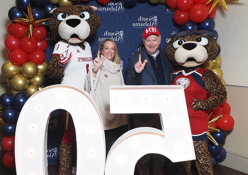 南 Alabama's 总统 Joe Bonner with his wife pose behind the "50" beside Ms. 宝拉和南爪