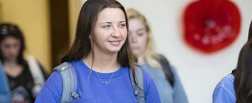 Female student with backpack on smiling