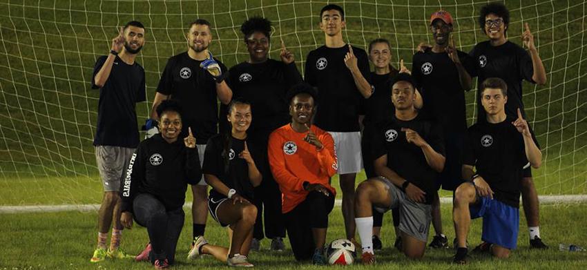 学生 in front of the soccer goal holding up number 1 with hands